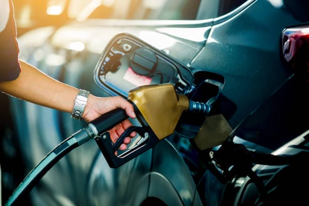 Une femme fait le plein de carburant dans sa voiture.